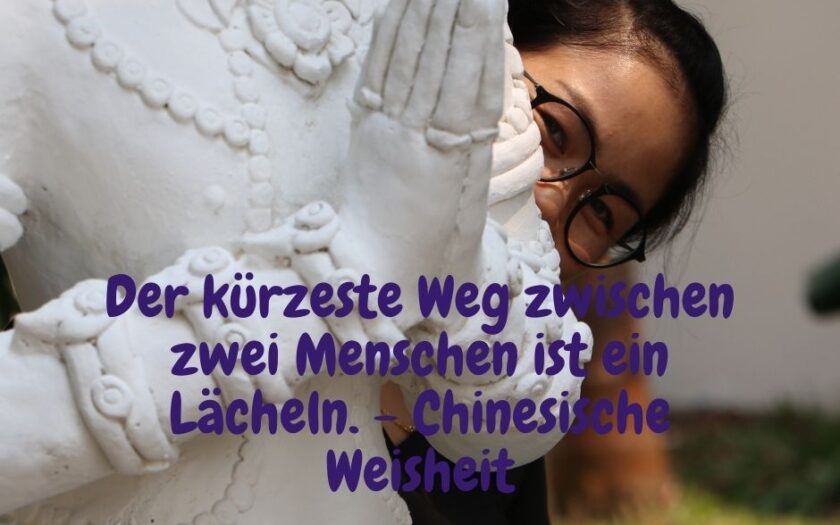 Lächelnde Thai Frau hinter einer Statue - Der kürzeste Weg zwischen zwei Menschen ist ein Lächeln. - Chinesische Weisheit